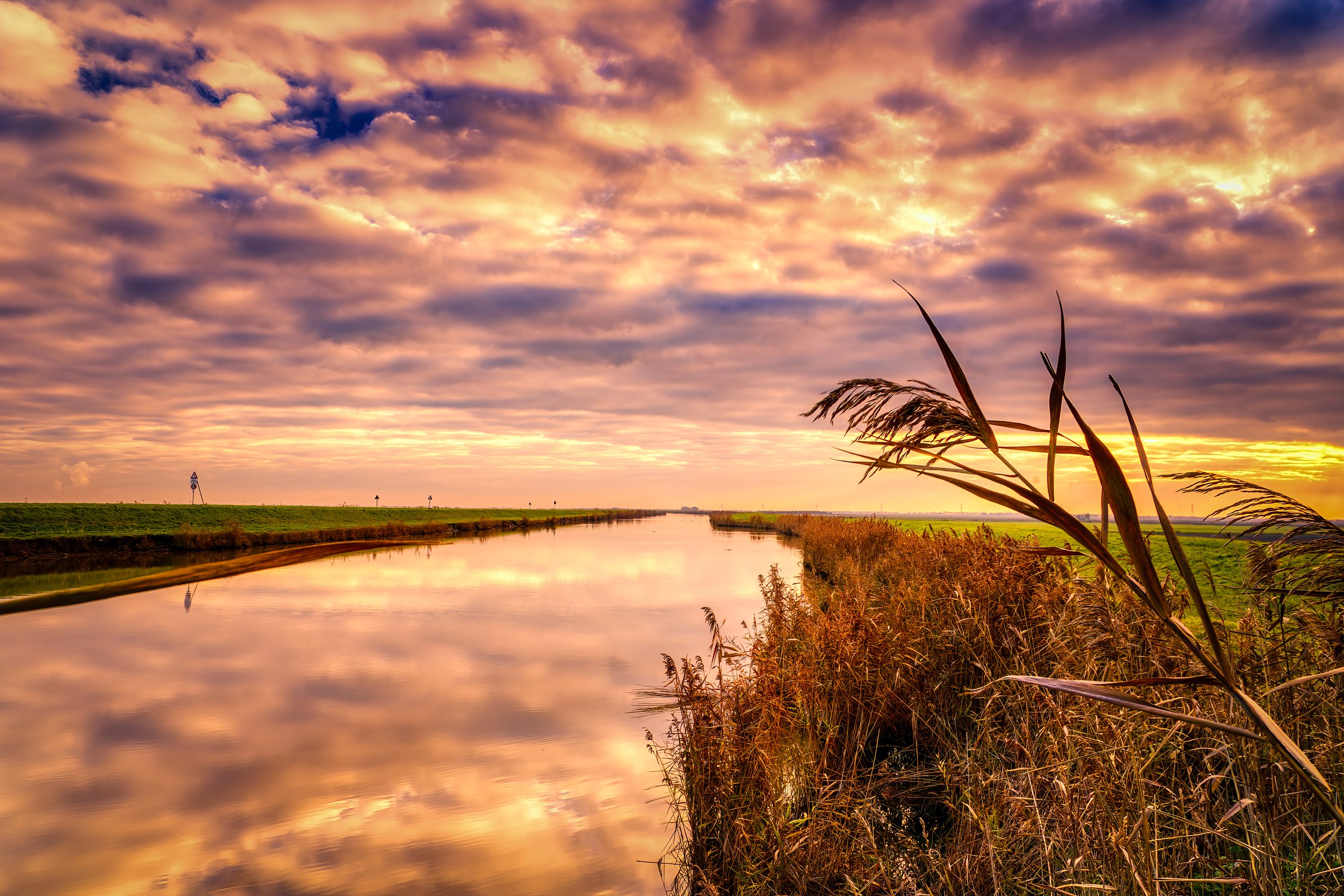 Sunset Magic: Driving Through the Valli di Comacchio Wetlands 2 Dramatic cloud formations reflected in still waters of Valli di Comacchio at sunset